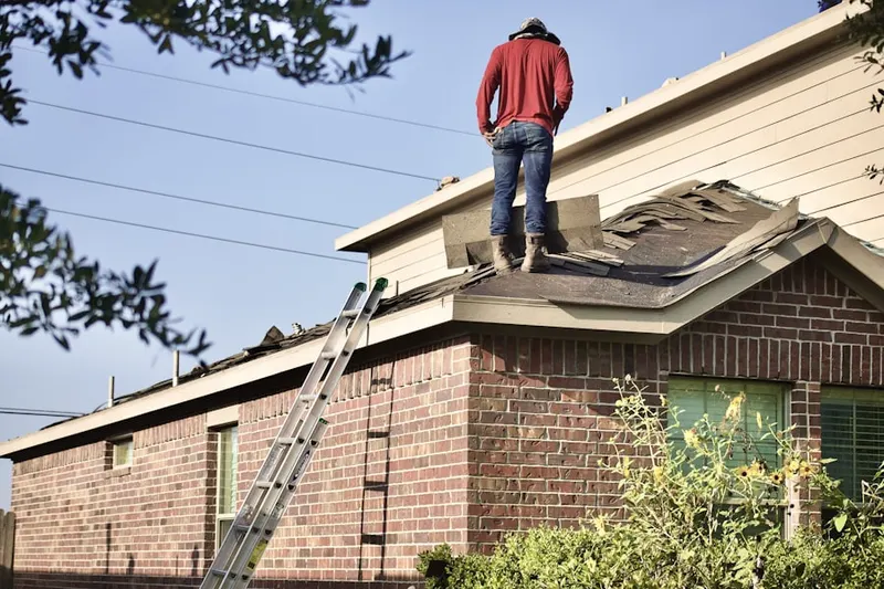 Professional roofer working on a residential roof in Rice
